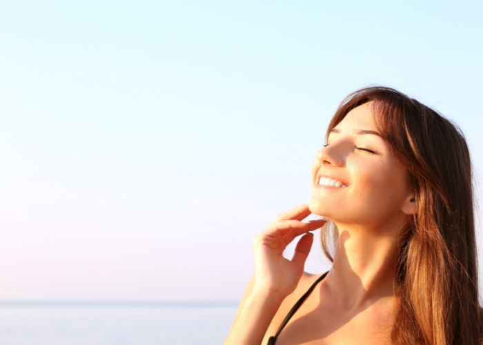 Female enjoying the sun on her face using natural sunlotions